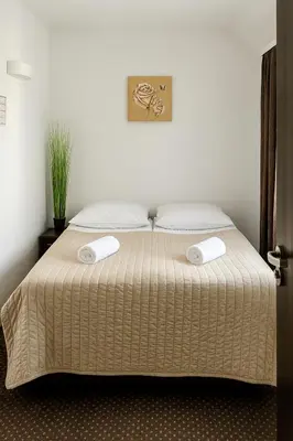 a bedroom with a bed with two pillows on it at Hotel Junior 2 in Kraków