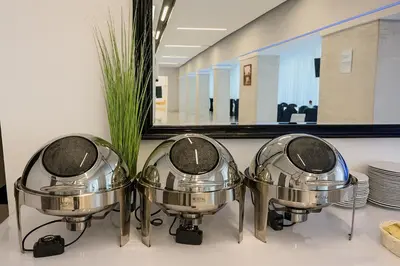 three metal pots on a counter in front of a mirror at Hotel Junior 2 in Kraków