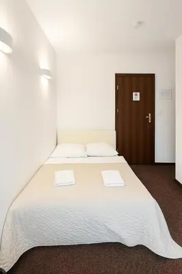a bedroom with a large bed with two towels on it at Hotel Junior 2 in Kraków