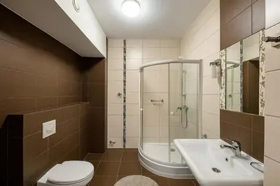 a bathroom with a shower toilet and a sink at Hotel Junior 2 in Kraków