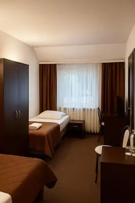 a hotel room with two beds and a window at Hotel Junior 2 in Kraków