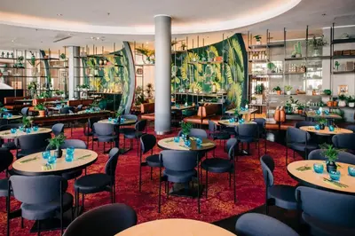 a restaurant with tables and chairs and windows at Vienna House by Wyndham Andel's Cracow in Kraków