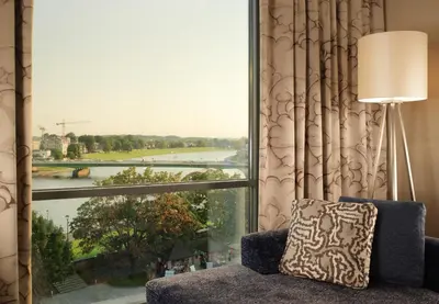 a room with a large window with a view of a river at Sheraton Grand Krakow in Kraków
