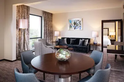 a living room with a table and chairs at Sheraton Grand Krakow in Kraków