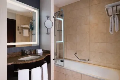a bathroom with a tub and a sink and a mirror at Sheraton Grand Krakow in Kraków