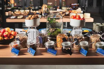 a table topped with jars of food and fruit at Sheraton Grand Krakow in Kraków