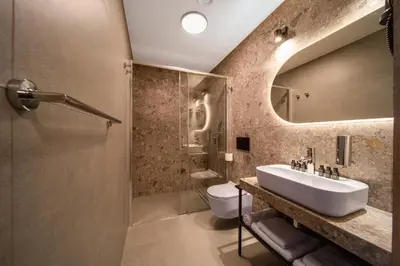 a hotel room with two beds and a room with two chairs at Hotel Alexander in Kraków