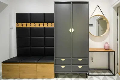 a black wardrobe with a mirror and a table at Powiśle 4 by Homeprime in Kraków