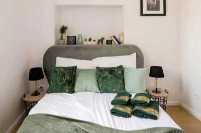 a bed with green and white pillows on it at Powiśle 4 by Homeprime in Kraków