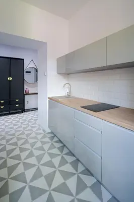 a kitchen with white cabinets and a tiled floor at Powiśle 4 by Homeprime in Kraków