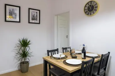 a dining room table with chairs and a clock on the wall at Powiśle 4 by Homeprime in Kraków