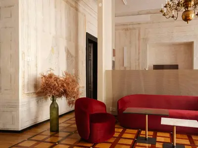 a living room with a red couch and a table at Hotel Pod Różą in Kraków