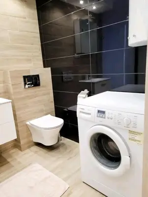 a bathroom with a washing machine and a toilet at Cracow NOVUM Apartment Downtown 4 persons in Kraków