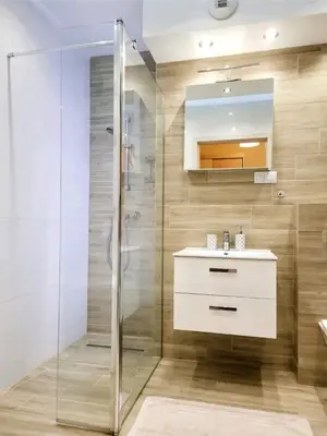 a bathroom with a glass shower and a sink at Cracow NOVUM Apartment Downtown 4 persons in Kraków