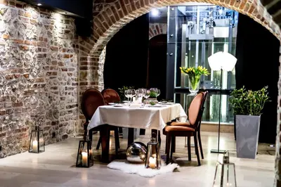 a dining room with a table and chairs and a brick wall at Hotel Rubinstein in Kraków