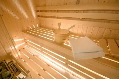 a sauna with a bucket and a towel in it at Hotel Rubinstein in Kraków