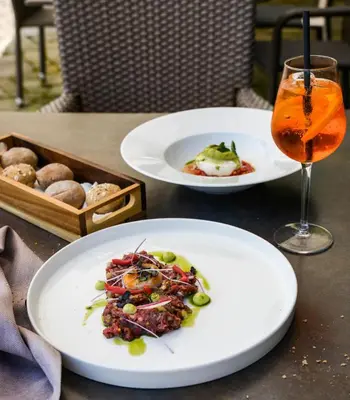 a table with two plates of food and a drink at Dwór w Tomaszowicach in Modlnica