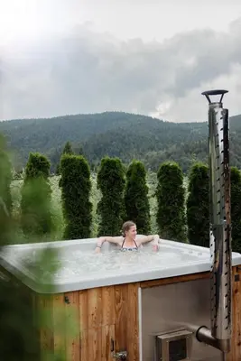 a woman in a bath tub on a roof at Jodłowa Chata in Myślenice