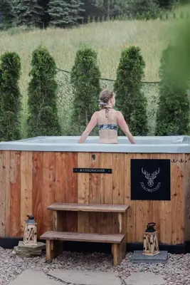 a woman standing in a hot tub with a bench at Jodłowa Chata in Myślenice