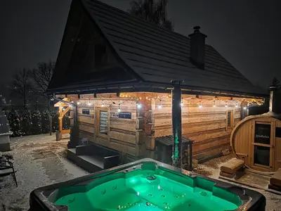 a log cabin with lights on the front of it at Jodłowa Chata in Myślenice