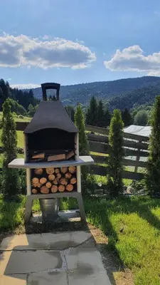 a grill with a pile of fire wood at Jodłowa Chata in Myślenice