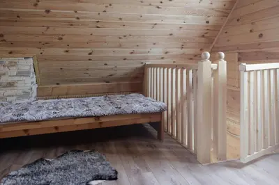 a bedroom with a bed in a wooden room at Jodłowa Chata in Myślenice