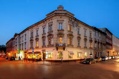 a large building with cars parked in front of it at Spatz Aparthotel in Kraków