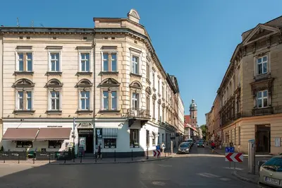 a building on a city street with people walking on the street at Spatz Aparthotel in Kraków