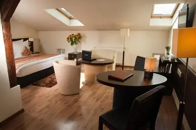 a bedroom with a bed and two tables and a bed at Spatz Aparthotel in Kraków