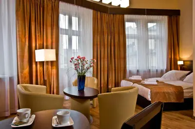 a hotel room with a bed and a table and chairs at Spatz Aparthotel in Kraków