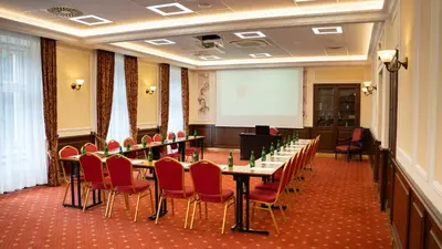 a conference room with tables and chairs and a whiteboard at Hotel Polonia in Kraków