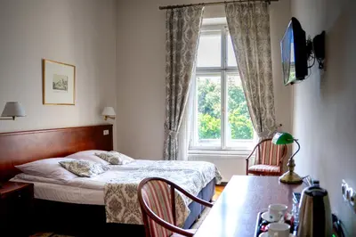 a small bedroom with a bed and a window at Hotel Polonia in Kraków