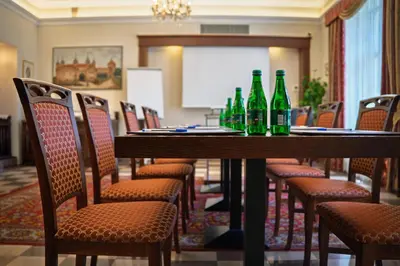 a conference room with bottles on a table with chairs at Hotel Polonia in Kraków