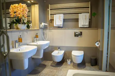 a bathroom with two sinks and a toilet and a mirror at Hotel Polonia in Kraków