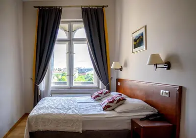 a bedroom with a bed with a large window at Hotel Polonia in Kraków