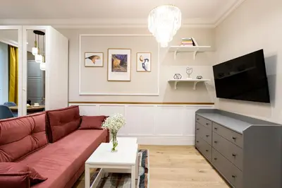 a living room with a red couch and a tv at Native Apartments Nowowiejska 9 in Kraków