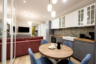 a kitchen and living room with a table and chairs at Native Apartments Nowowiejska 9 in Kraków