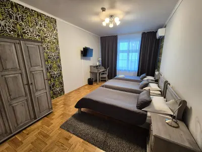 a bedroom with three beds and a door at Hotel Mikołaj in Kraków
