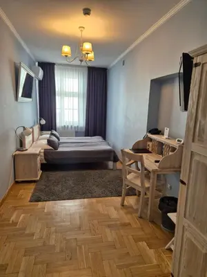 a bedroom with a bed and a table in a room at Hotel Mikołaj in Kraków