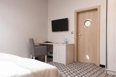 a room with a bed and a desk with a television at Piwnica Rycerska Kęty in Kęty