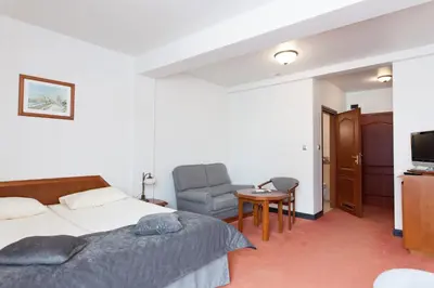 a bedroom with a bed and a chair and a television at Piwnica Rycerska Kęty in Kęty