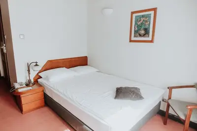 a bedroom with a bed and a chair and a picture at Piwnica Rycerska Kęty in Kęty
