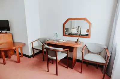 a room with a table and chairs and a mirror at Piwnica Rycerska Kęty in Kęty
