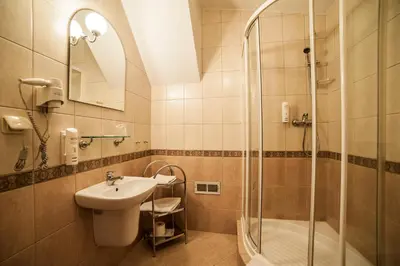 a bathroom with a sink and a shower at Piwnica Rycerska Kęty in Kęty