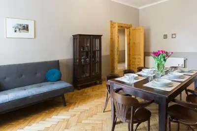 a dining room with a table and a couch at Antique Apartments Plac Szczepański in Kraków
