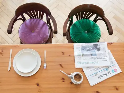 a wooden table with two chairs with plates and a table at Antique Apartments Plac Szczepański in Kraków