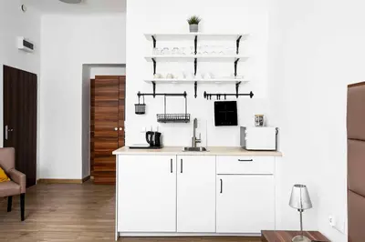 a kitchen with white cabinets and a white wall at Charming Apartment, Wawel & Old Town Krakow II in Kraków