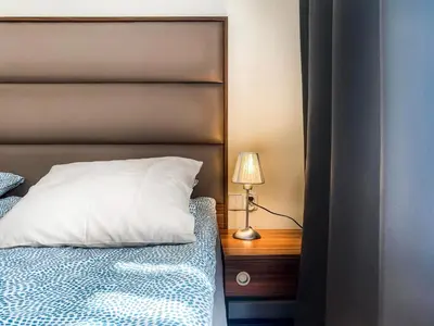 a bed with a white pillow and a lamp on a night stand at Charming Apartment, Wawel & Old Town Krakow II in Kraków
