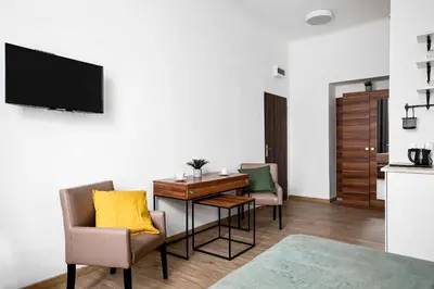 a living room with a table and chairs and a television at Charming Apartment, Wawel & Old Town Krakow II in Kraków