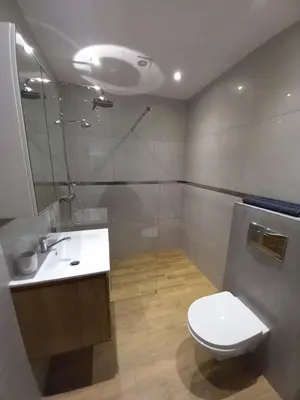 a bathroom with a toilet and a sink and a shower at Apartament przy Obozie in Oświęcim